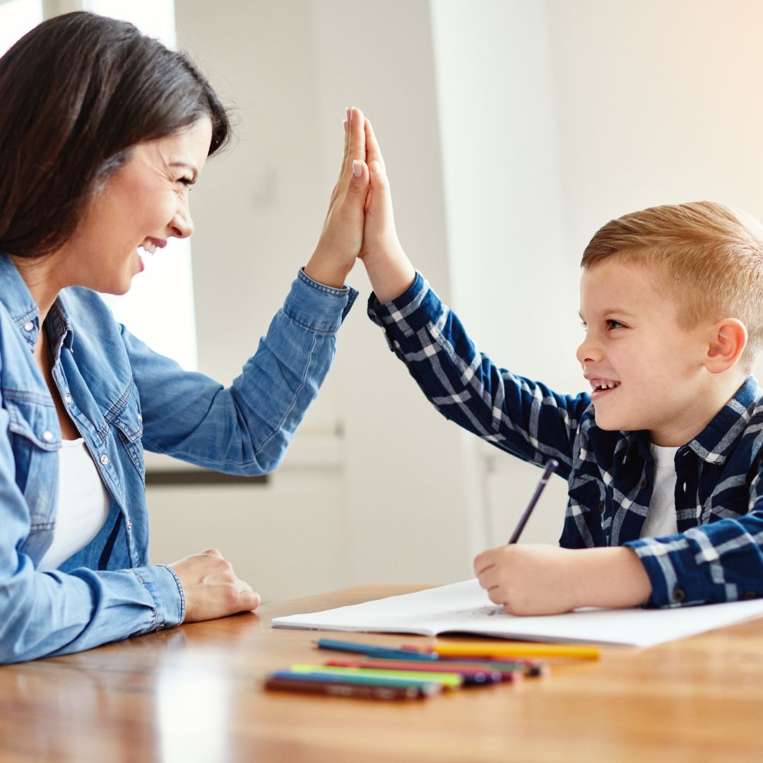Woman giving young boy a high five.