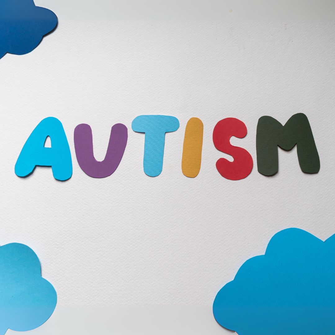 Autism spelled out in paper cut out with paper clouds