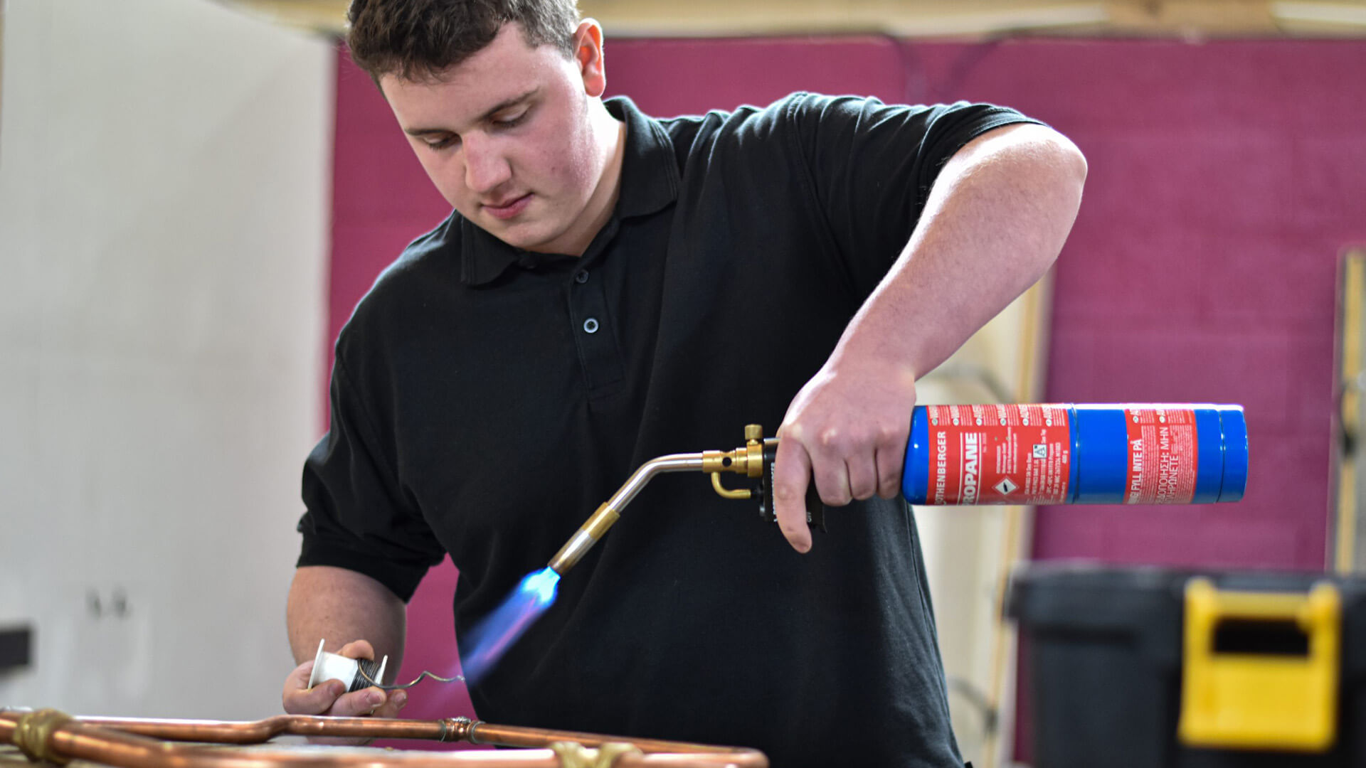 Man holding blow torch bends pipes
