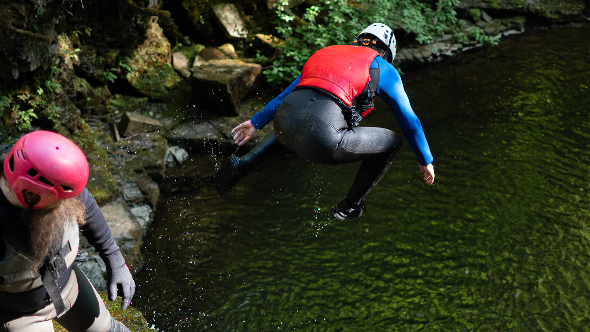 Teenager in high vis jumping into pool