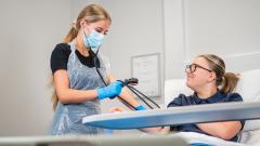 Students in hospital ward checking blood pressure